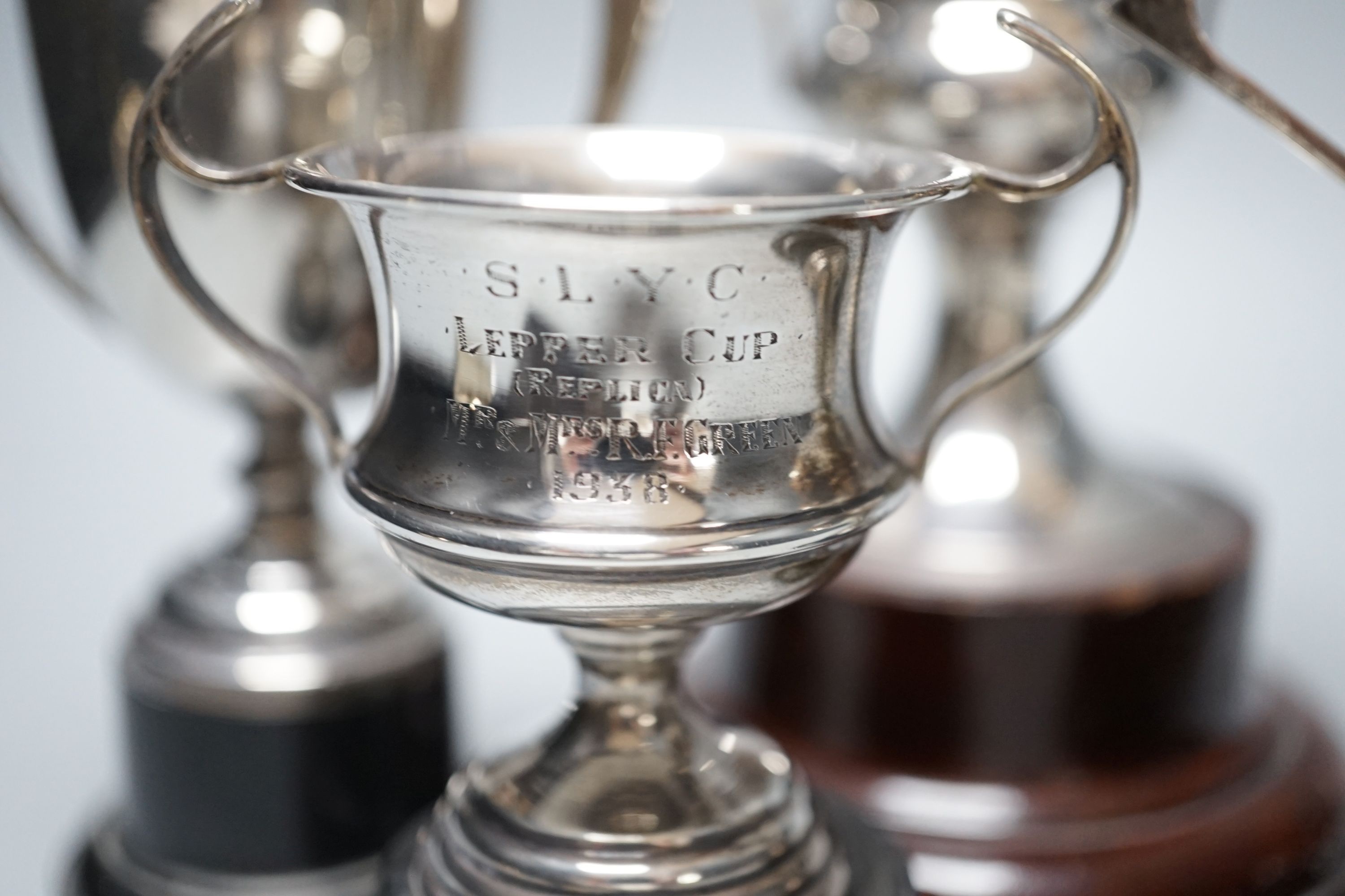 Five assorted 1920's/1930's silver two handled presentation trophy cups, all with engraved inscriptions and all with stands, largest 11.8cm.